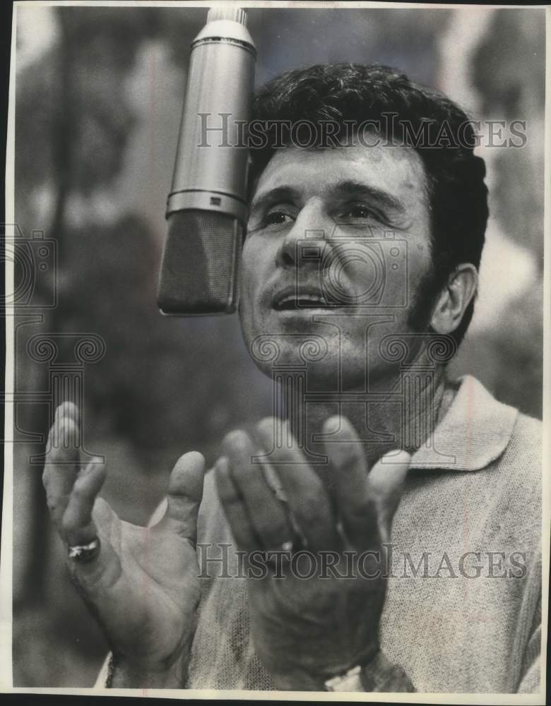 1965, United States Singer John Raitt sings into a microphone - Historic Images