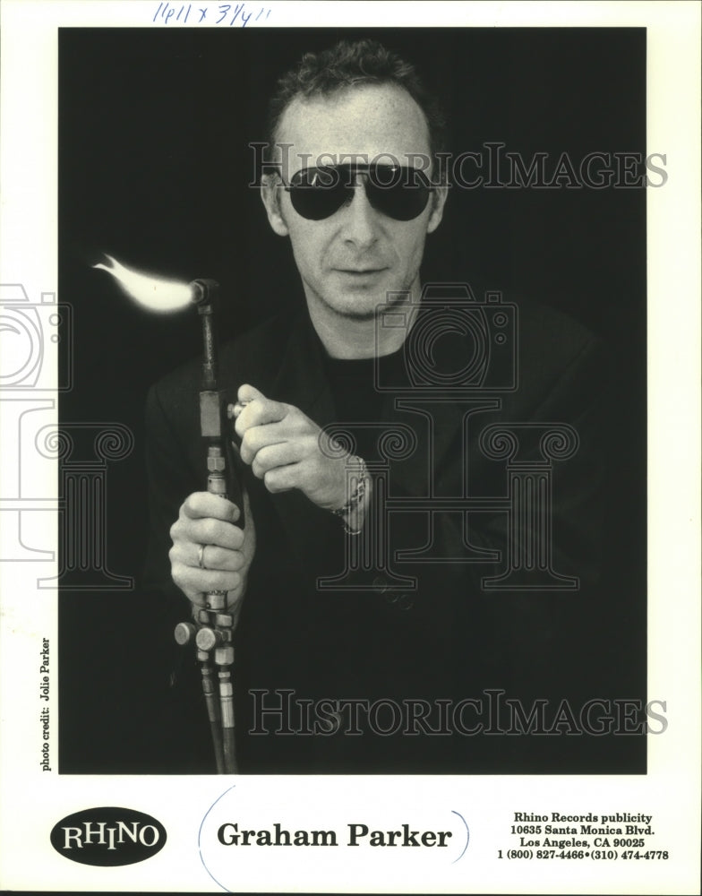 1984, Musician Graham Parker lights a torch. - mjp30281 - Historic Images