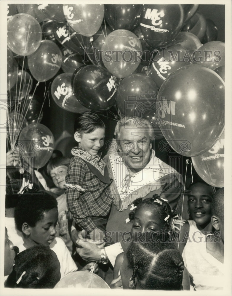 1987, Buffalo Bob Smith holds Timmy Dobrinska at Mitchell Airport. - Historic Images