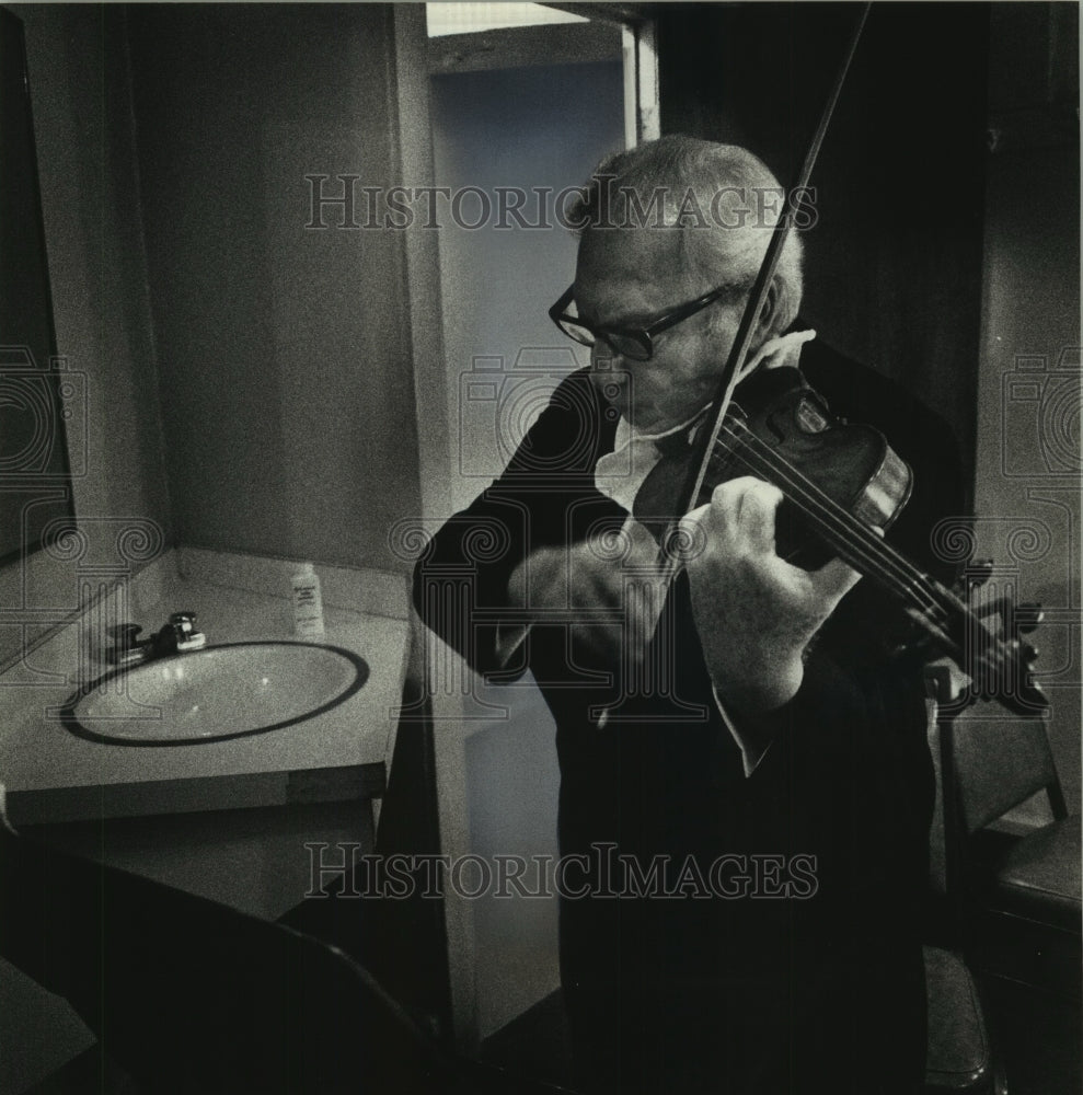 1989 Violinist Isaac Stern warms up in his dressing room - Historic Images