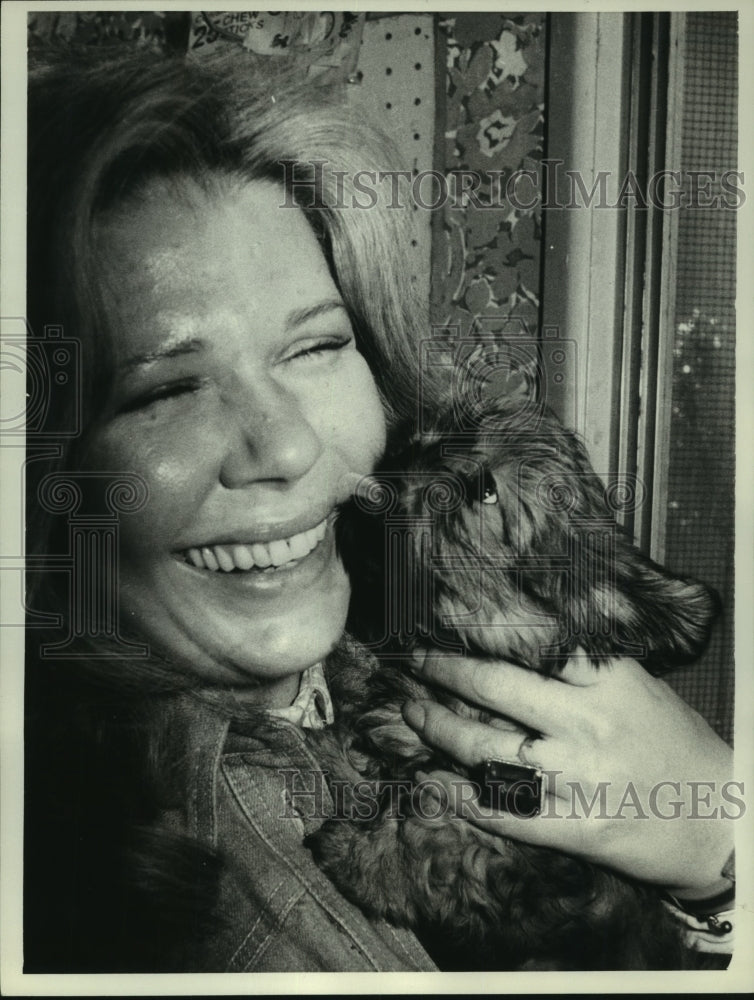 1975, Actress Loretta Swith cuddles a puppy in a New York pet shop - Historic Images