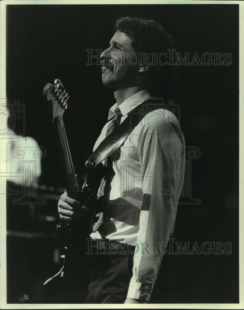 1983, Guitarist Daryl Stuermer with performs Phil Collins. - Historic Images