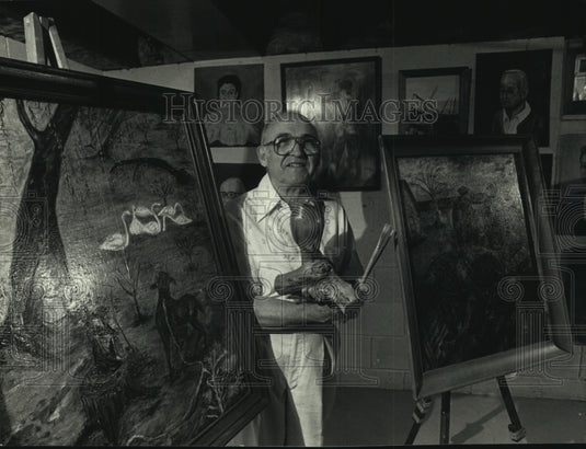 1991, Artist Hugo Roman with his oil paintings & wood carving, WI - Historic Images