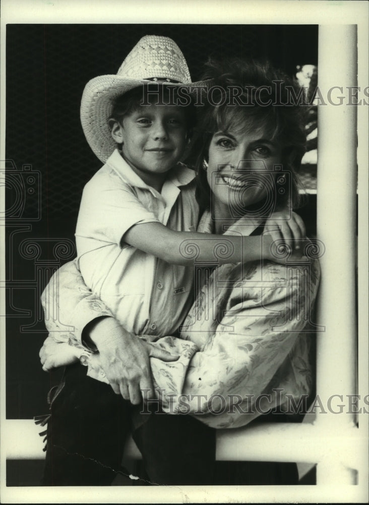 1985, actress Linda Gray & actor Omri Katz on the set of "Dallas" - Historic Images