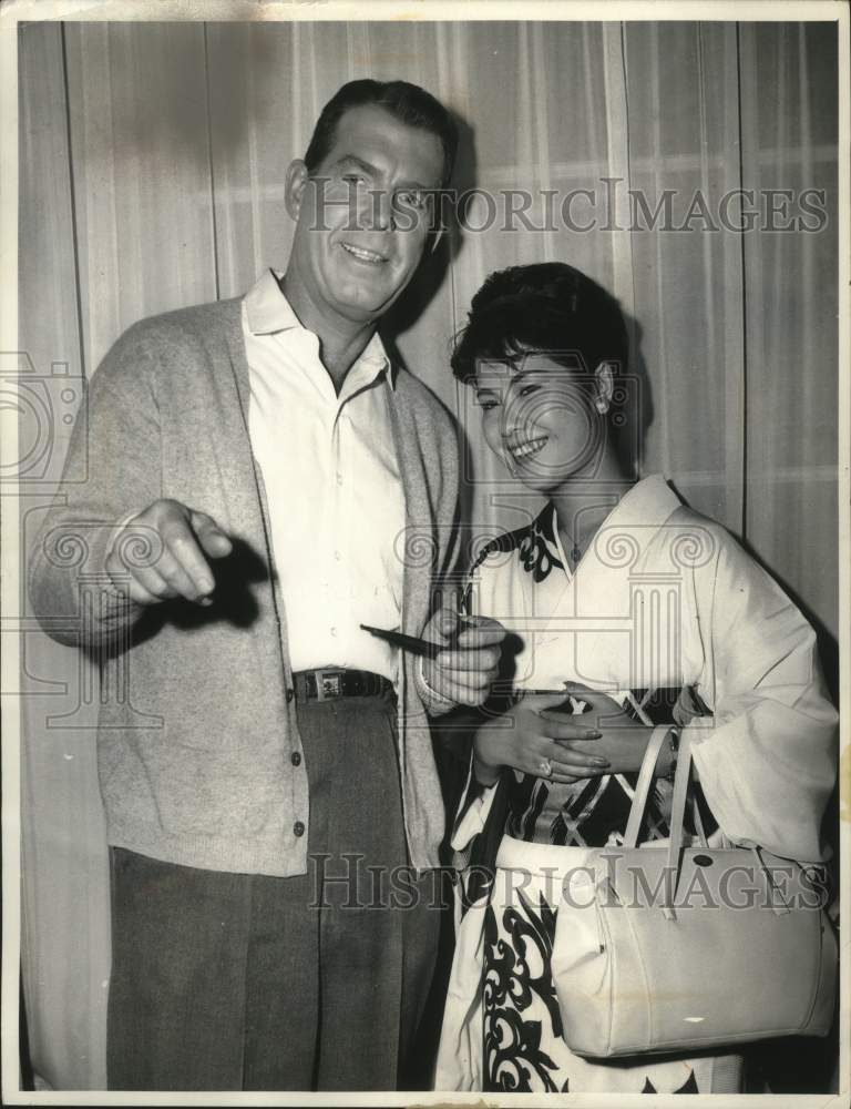 1961 Fred MacMurray and Peggy Hayami on the Hollywood TV set. - Historic Images