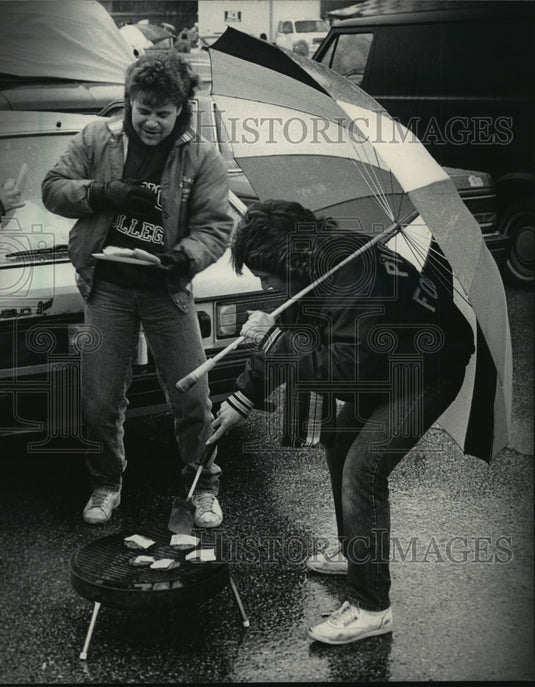 1986 Press Photo Milwaukee Brewers fans have burgers during Opening Day delay - Historic Images