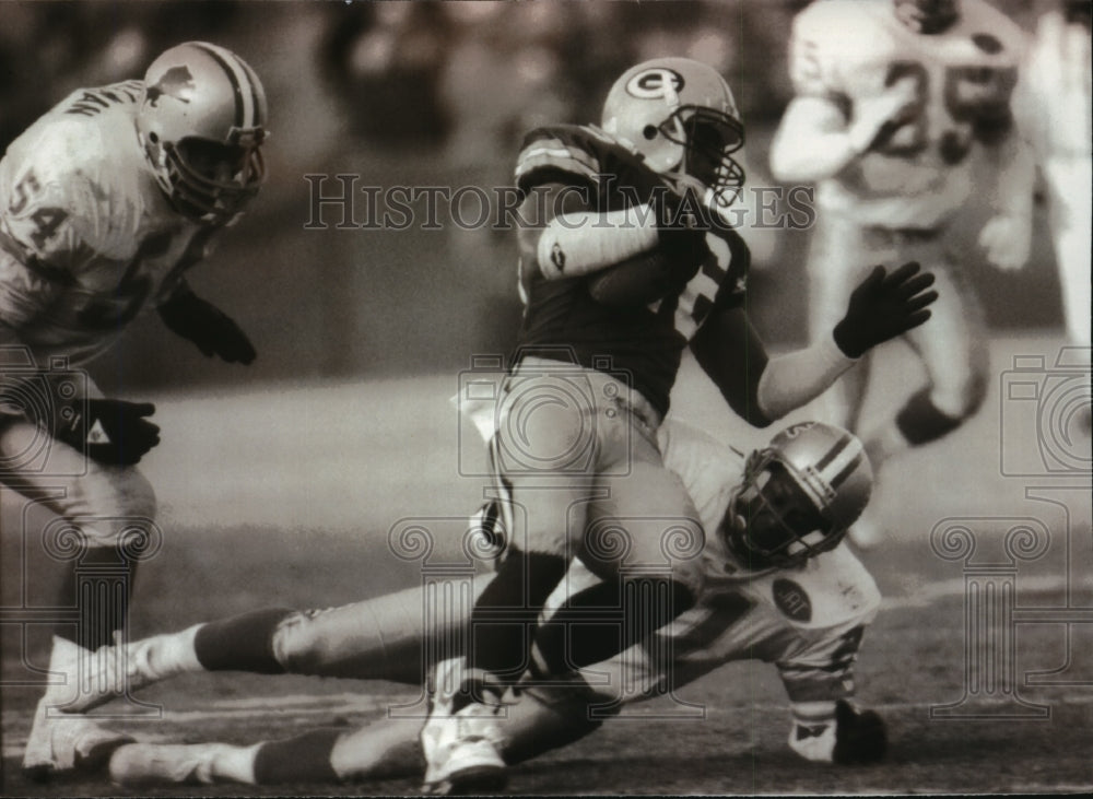 1991 Vince Workman tackled by Lions&#39; players in football game - Historic Images