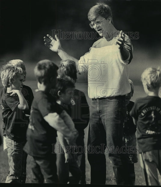 1987 Press Photo Coach Tom Kumerow coaches a young flag-football team - Historic Images