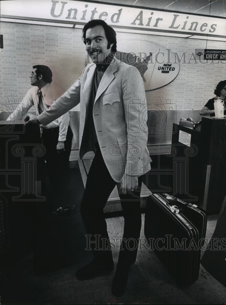 1973 Dick Cunningham at the ticket counter at the airport - Historic Images