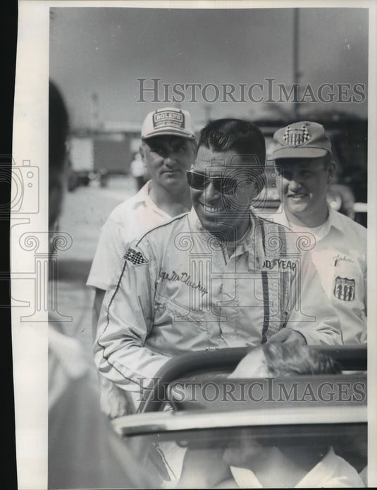 1969 Race car driver Roger McCluskey riding in an open car. - Historic Images