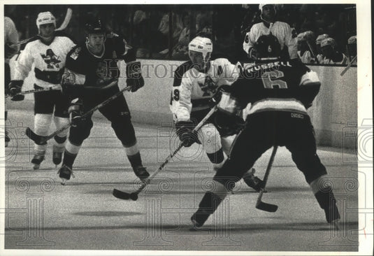 1990 Press Photo Milwaukee hockey's Peter DeBoer brings puck between 2 defenders - Historic Images