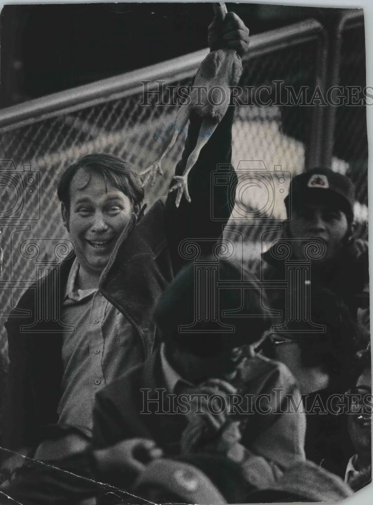 1977 Press Photo A disgruntled Green Bay Packers fan holds a chicken during game - Historic Images