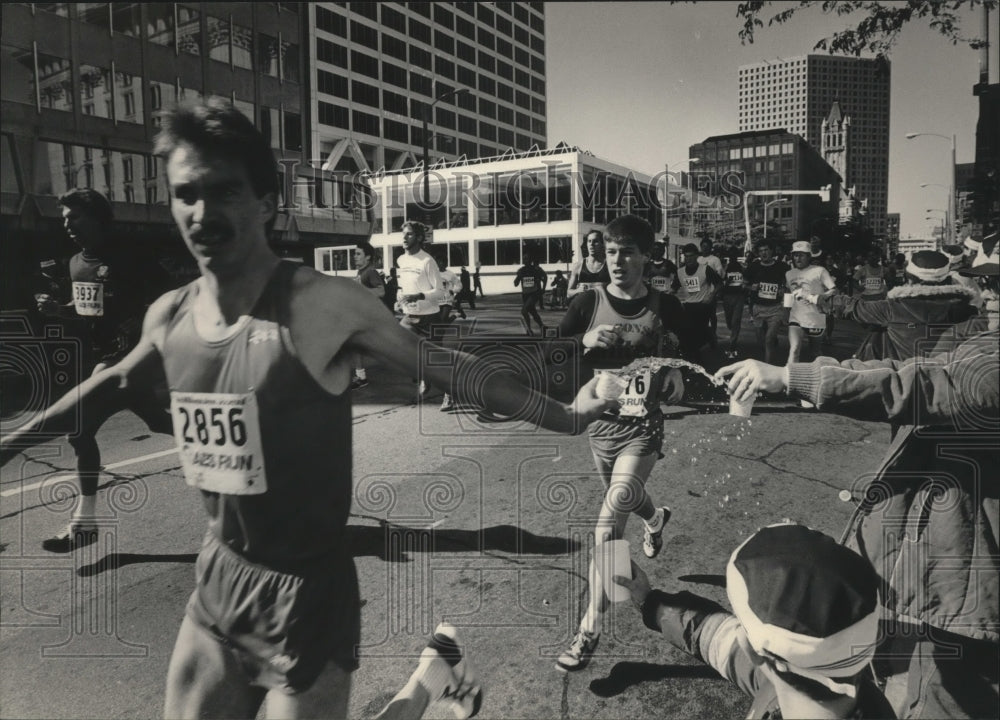 1984 Press Photo Racers grab water in the Al McGuire Race, Milwaukee, Wisconsin - Historic Images