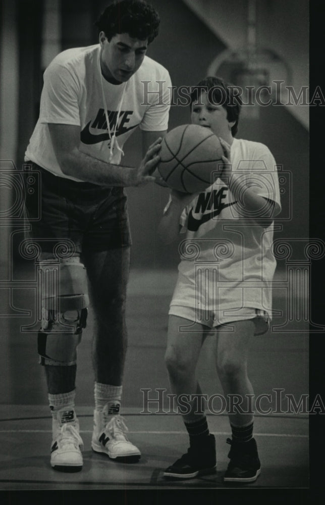 1986 Press Photo Former Marquette Warrior Marc Marotta helps out Jason Gray - Historic Images