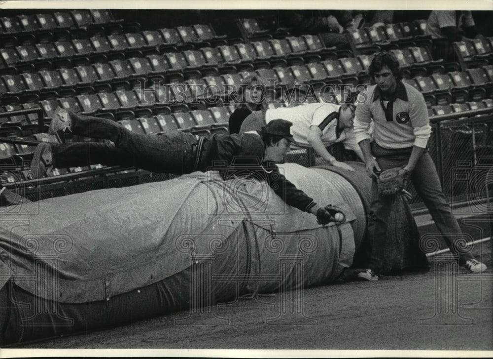 1985 Press Photo Milwaukee Brewer fan snatches foul ball over rail & tarp roll- Historic Images