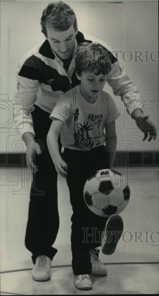 1986 Press Photo Steve Swanson of Wave demonstrats soccer to child, Milwaukee. - Historic Images