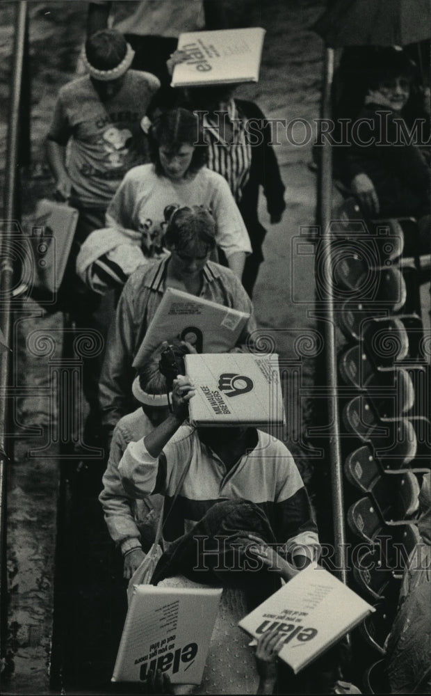 1986 Press Photo Several Brewer fans cushioned themselves from rain. - mjt10631 - Historic Images