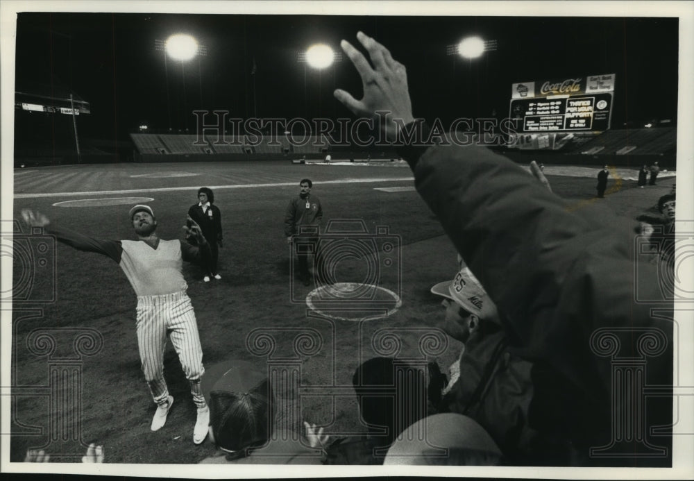 1990 Press Photo Pitcher Ron Robinson hurls ball to crowd after game, Milwaukee. - Historic Images