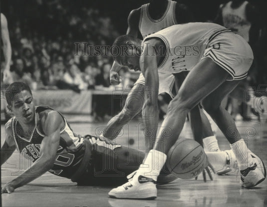 1986 Press Photo Marquette basketball's Benny Moore tries to scoop loose ball- Historic Images