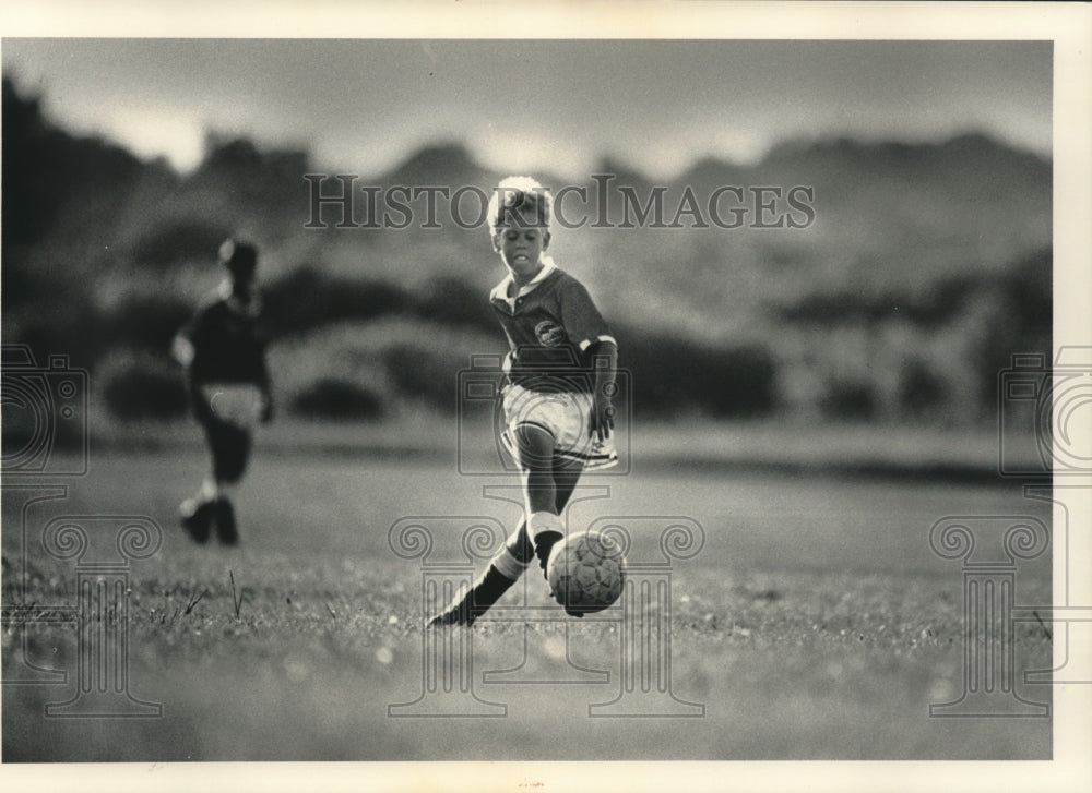 1991 Press Photo A young soccer player dribbles the ball downfield - mjt14520 - Historic Images