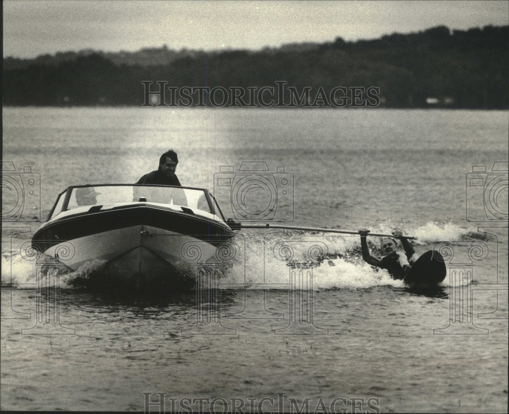 1989 Water skier Tom Schultz tries &quot;sit ski&quot; on Pewaukee Lake - Historic Images