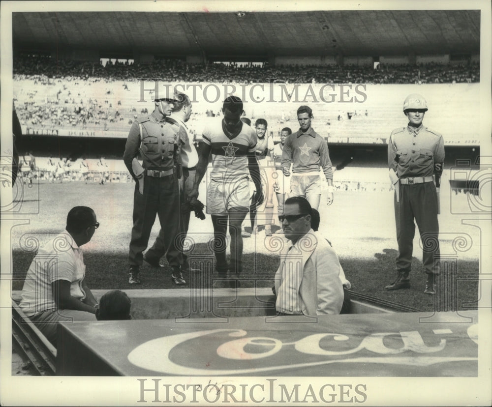 1960 Press Photo Soccer Players Guarded By Military Policeman In South America - Historic Images