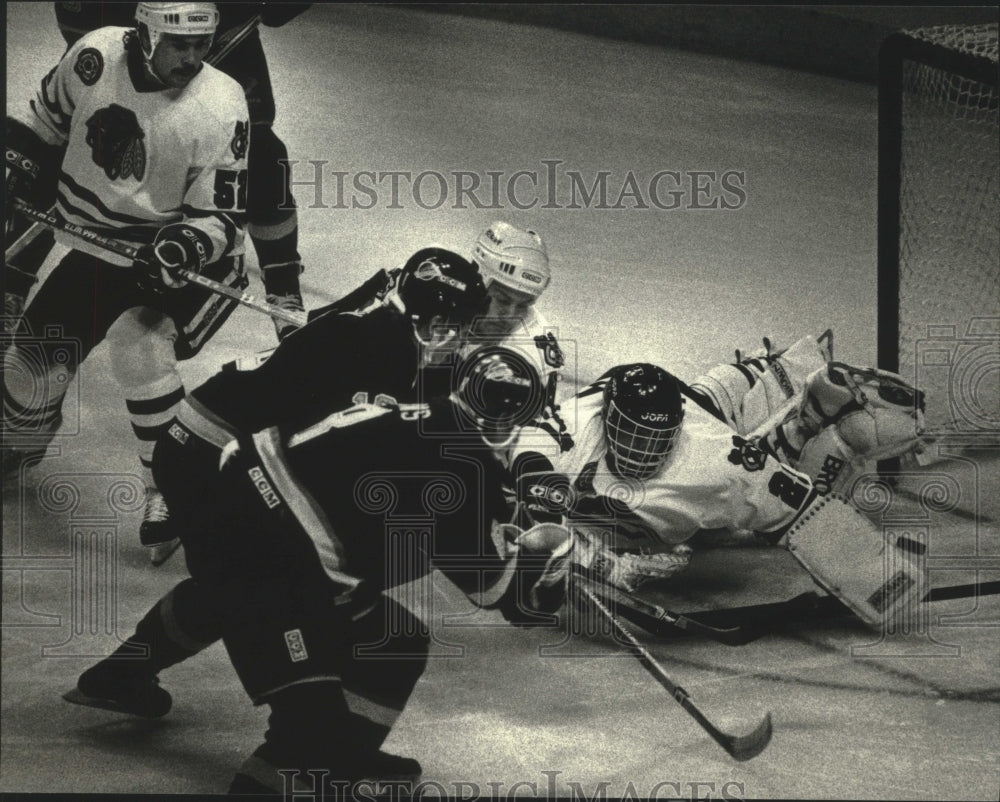 1990 Vancouver hockey&#39;s Greg Adams slides puck past opponent - Historic Images