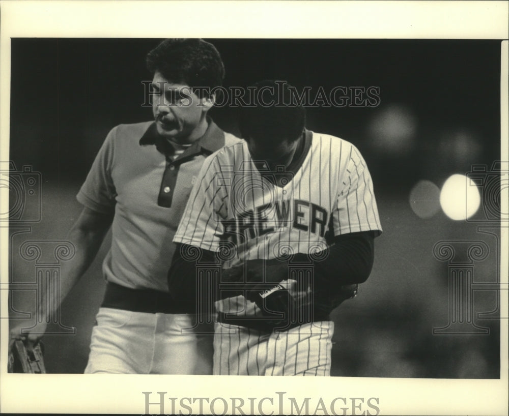 1985 Brewers baseball trainer John Adams assists injured Dion James - Historic Images