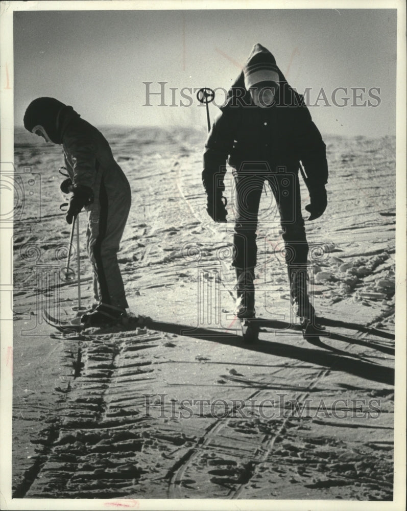 1977 Press Photo Child and adult practice down hill skiing on small hill.- Historic Images