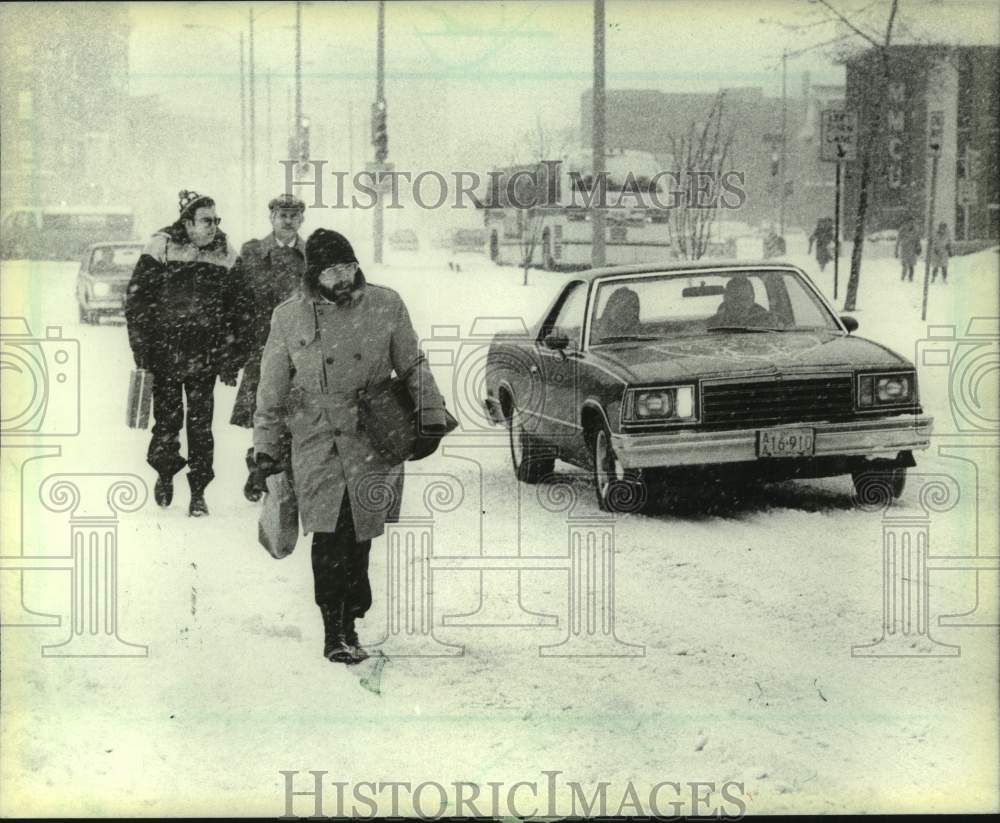 1983 Press Photo Pedestrians walk alongside cars during snowstorm in Milwaukee- Historic Images