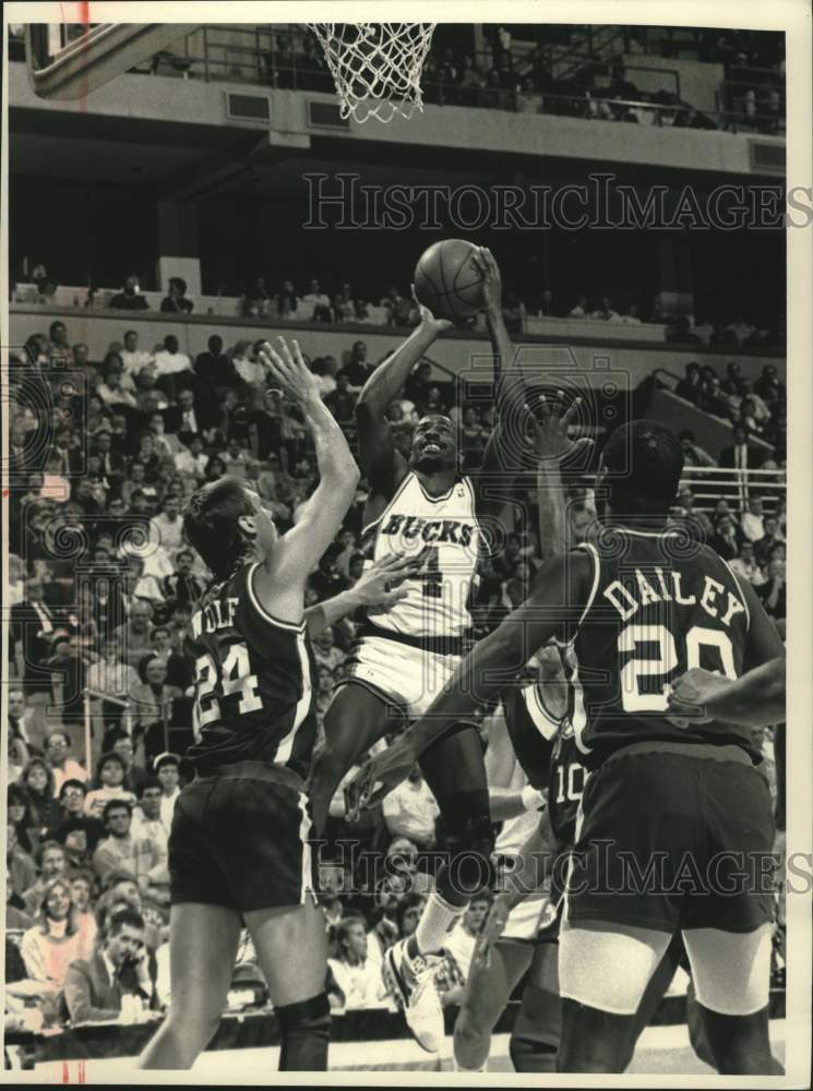 1989 Press Photo Buck&#39;s Sidney Moncrief jumps to shoot over Clippers&#39; Joe Wolf. - Historic Images