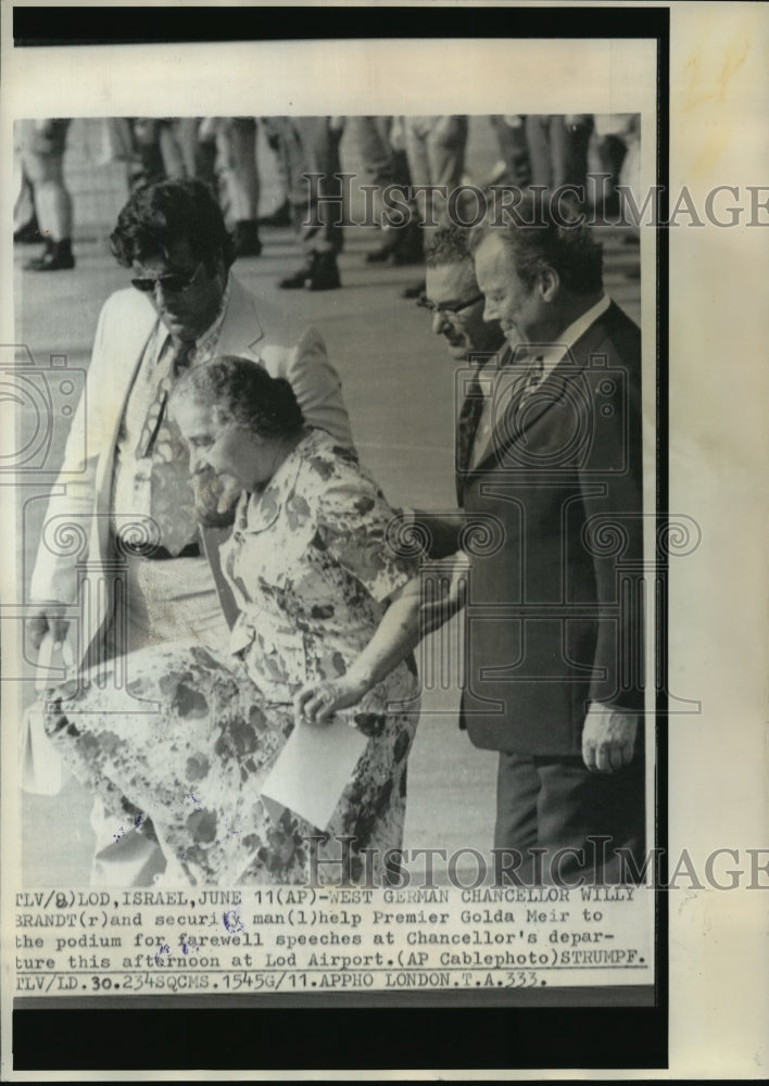 1973 Press Photo Chancellor Willy Brandt helps Premier Golda Meir in Lod, Israel - Historic Images