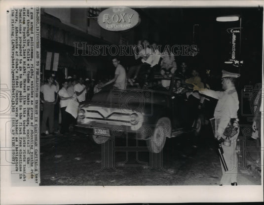 1962 Press Photo Tear gas armed policeman watch Demonstrators, Santo Domingo, DO - Historic Images