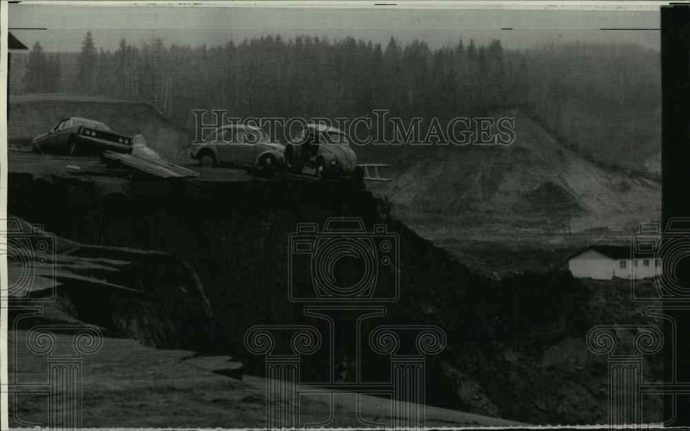 1971 Press Photo Cars teeter on edge of sinkhole in St. Jean Vianney, Quebec. - Historic Images