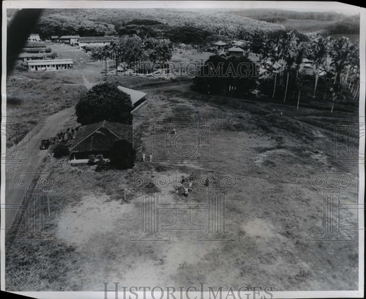 1954 Malaysia estate owner signals to pilot to drop a plane pay load - Historic Images