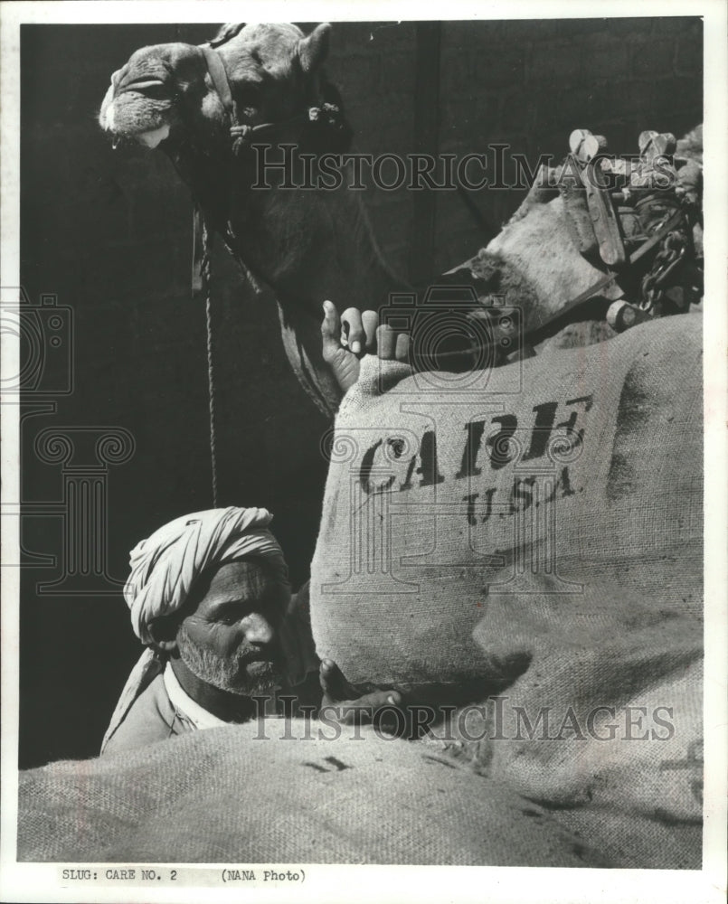 1972 Press Photo Indian lifting CARE package on his camel&#39;s back in India-Historic Images