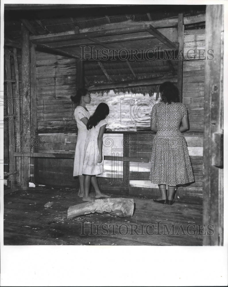 1962 Press Photo Women from modest home look out window at boats passing by.-Historic Images