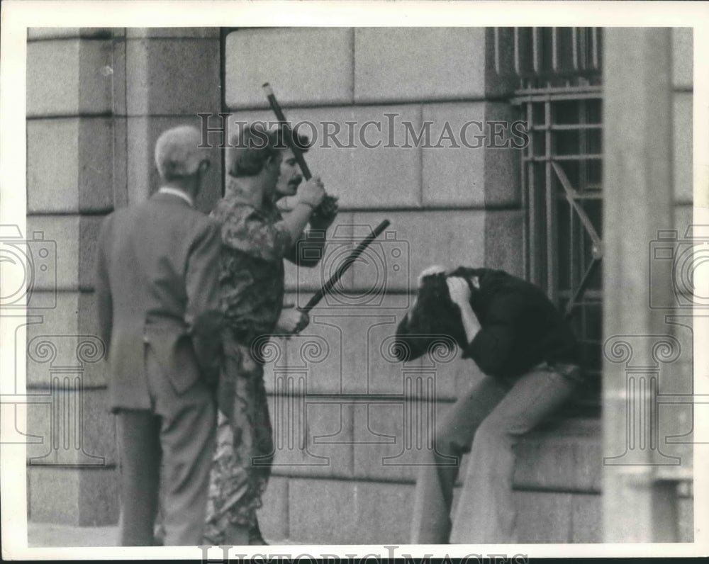 1976 Press Photo Police clubs a man during unrest in Cape Town, South Africa. - Historic Images