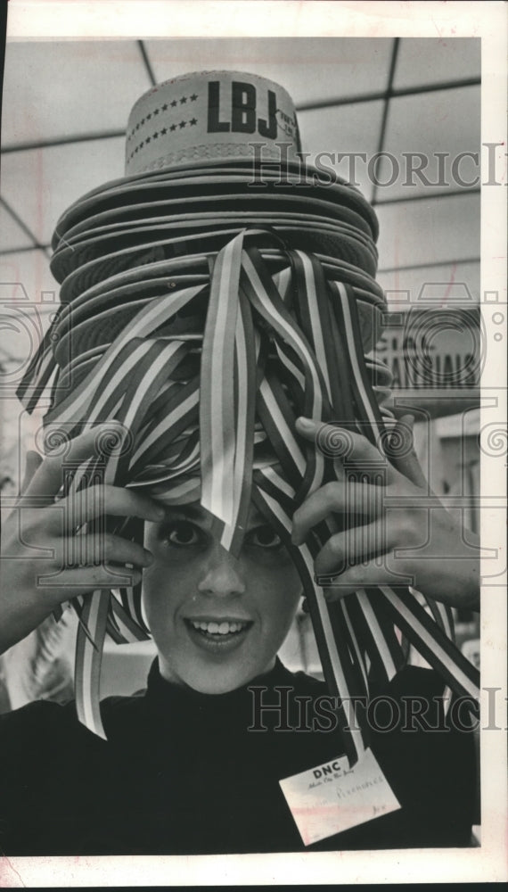 1964 Press Photo Felicia Plerhoples peeking from stack of President Johnson hats - Historic Images