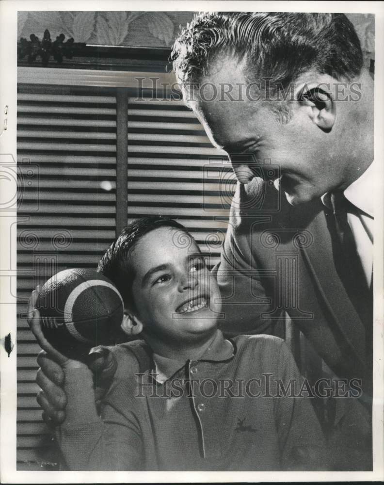 1963 Johnny Bohn shares possession of a football with Paul Hornung - Historic Images