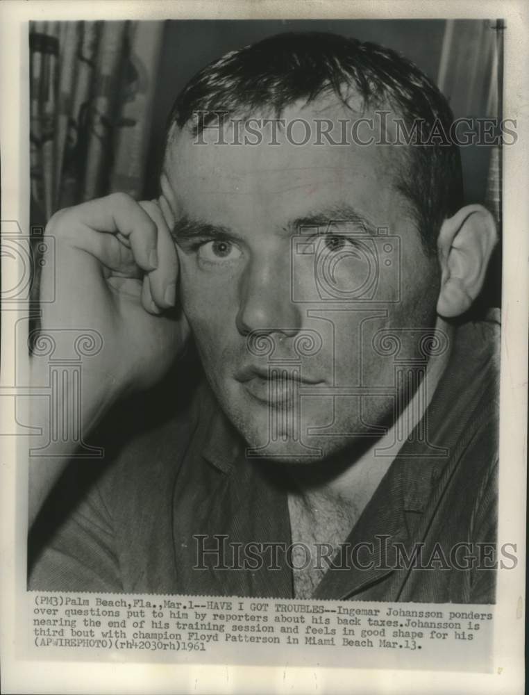 1961 Boxer Ingemar Johansson ponders questions from reporters - Historic Images