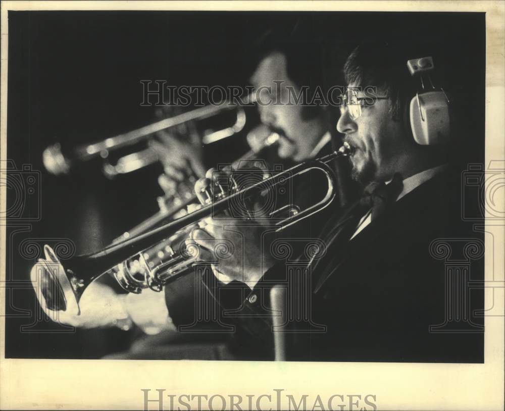 1986 Trumpet Player wears earphones to pick up cues in performance - Historic Images