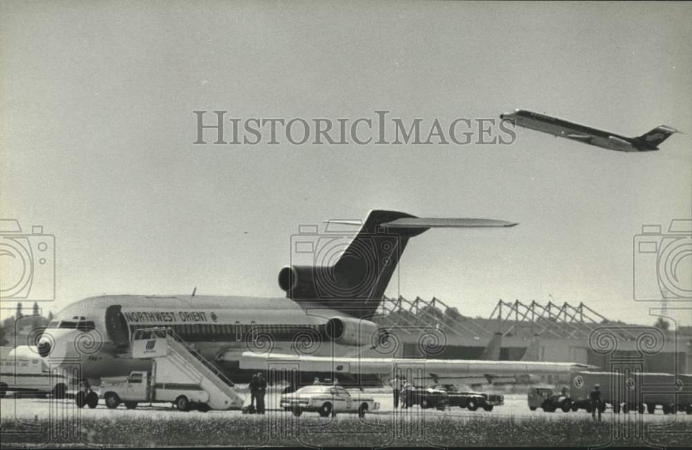 1980 Northwest 727 surrounded by security after bomb threat. - Historic Images