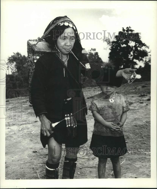 1967 Akha tribeswoman unwinds spool of bamboo fiber in Thailand-Historic Images