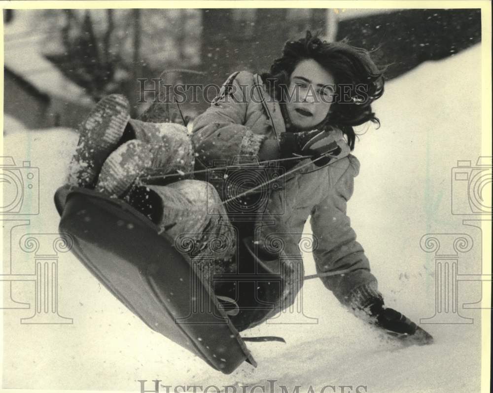 1988 Press Photo Girl Sledding Down High School Hill, Hancock, MI - mjx80394- Historic Images