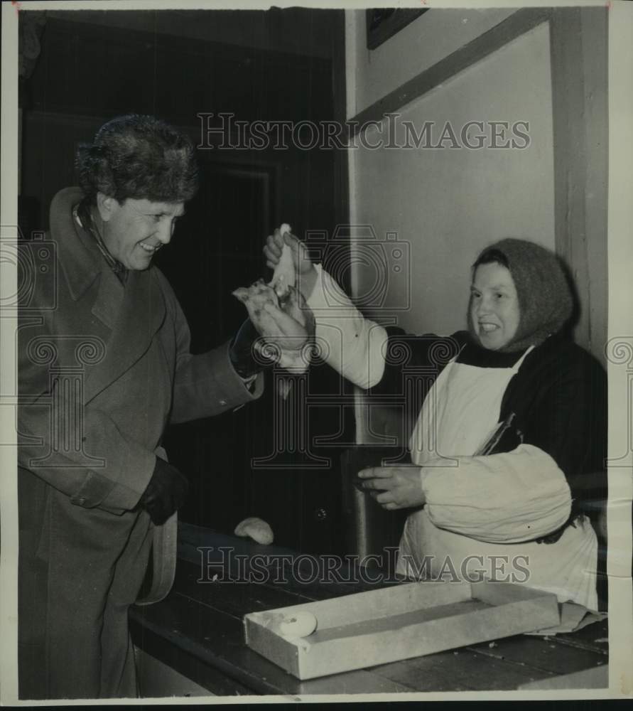 1955 William R. Hearst Jr. inspects chicken at open market in Russia - Historic Images
