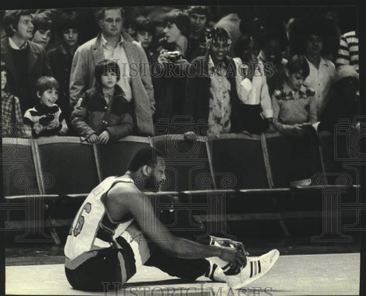 1980 Press Photo Milwaukee center Bob Lanier sits down to tie his shoe at game. - Historic Images