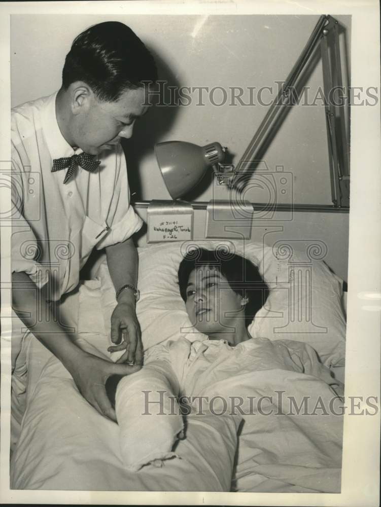 1955 Press Photo Tomoko Nakabayshi comforted by Dr. Tomin Harada, New York. - Historic Images