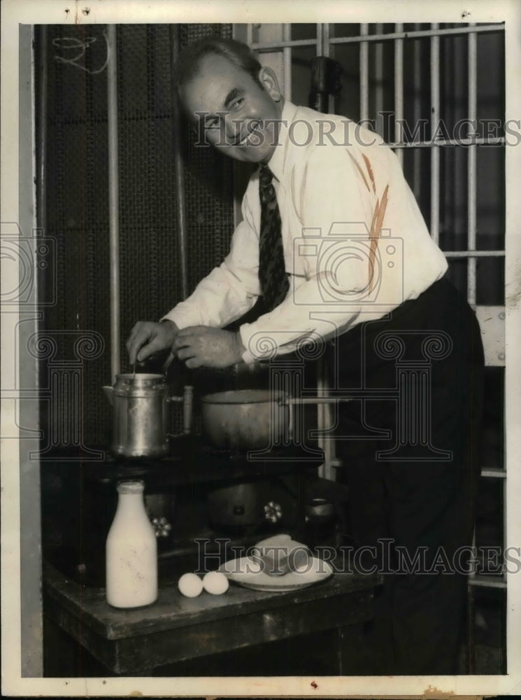 1933 Press Photo Tom Mooney cooking in his cell while he awaits his trial - Historic Images