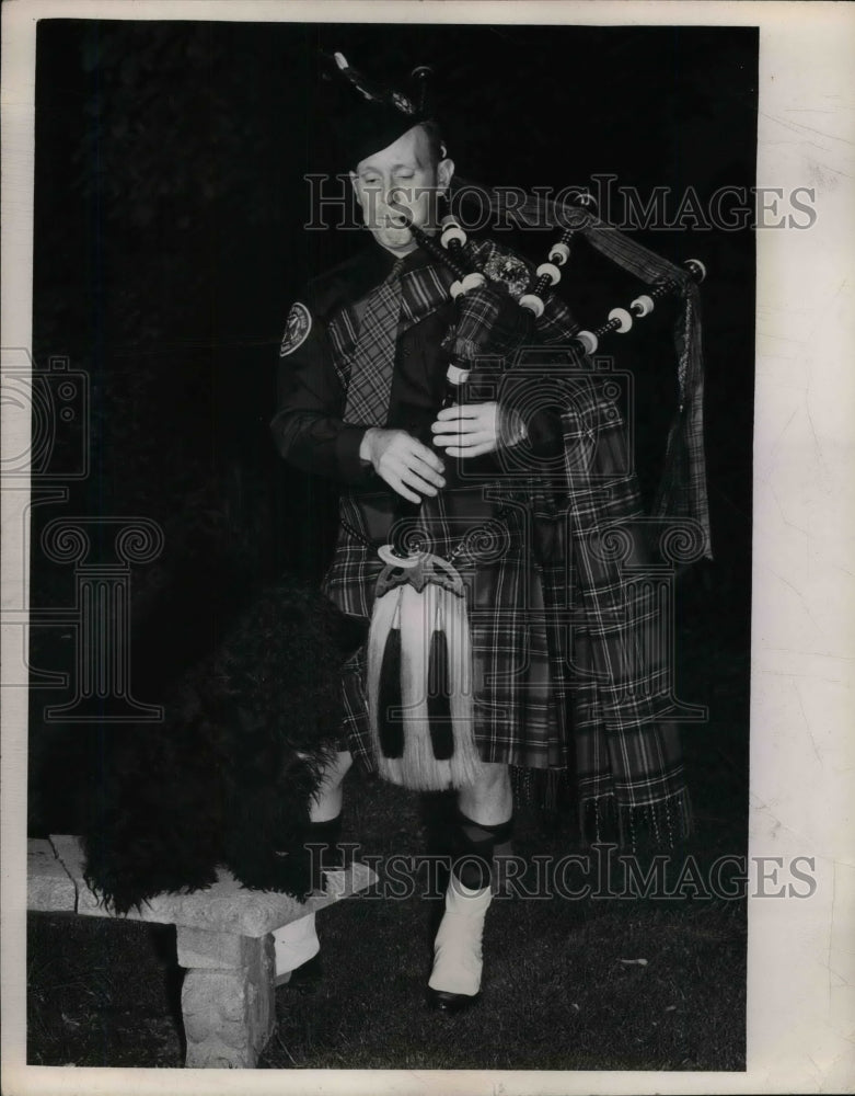 1949 Press Photo W. Harris in Scottish Costume playing bagpipes to hid dog - Historic Images